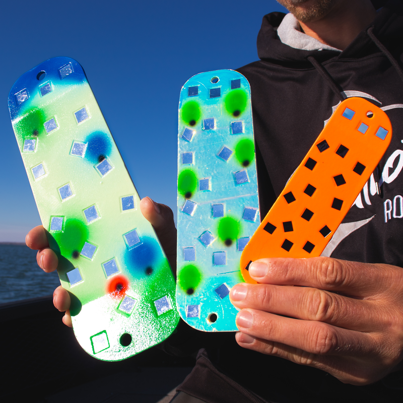 Person holding colorful moonshine mirrored flashers against a blue sky.